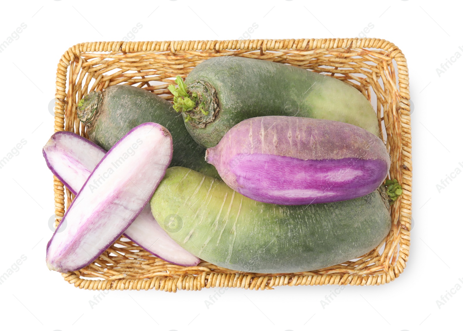 Photo of Purple and green daikon radishes in wicker basket isolated on white, top view