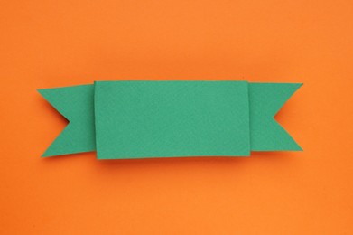 Photo of Paper ribbon on orange background, top view. Space for text