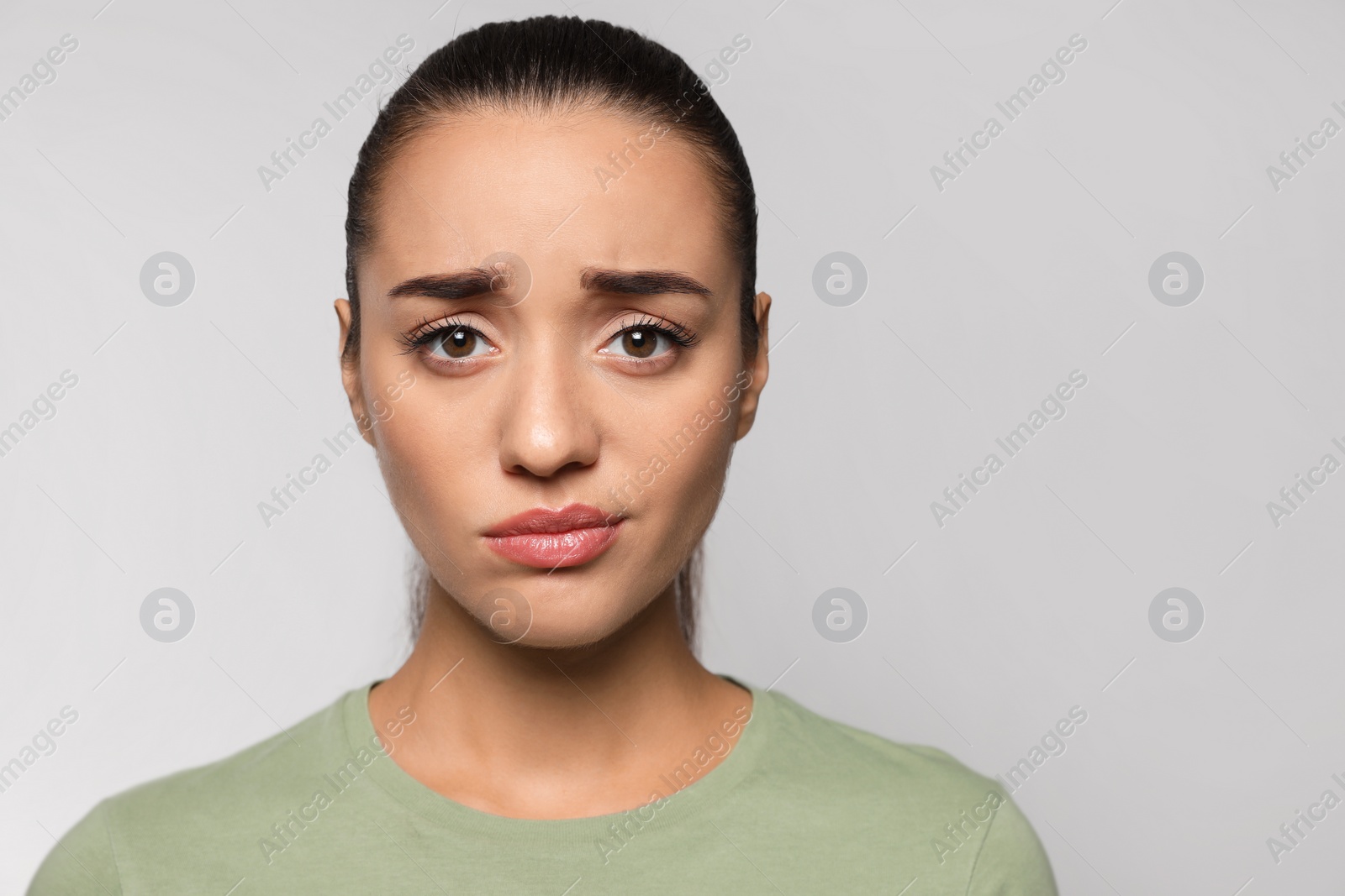 Photo of Emotional woman with herpes on lips against light grey background. Space for text