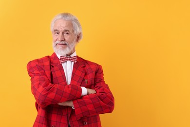 Portrait of grandpa with stylish red suit and bowtie on yellow background, space for text