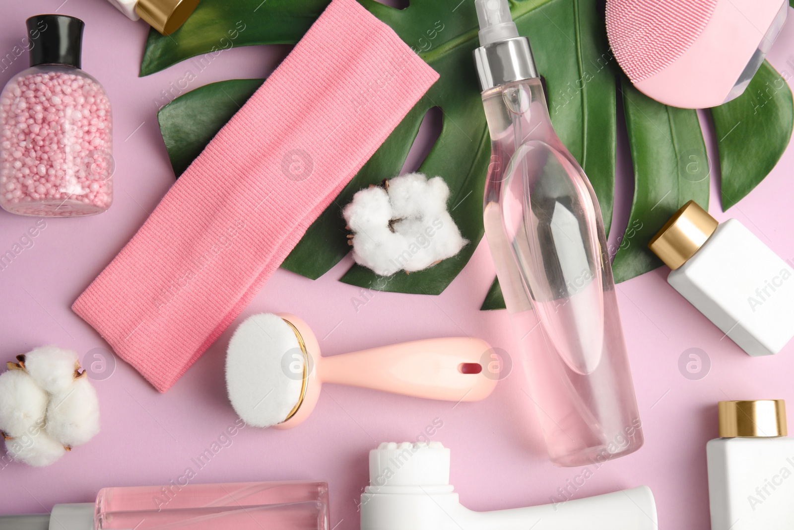 Photo of Flat lay composition with face cleansing brushes on violet background. Cosmetic tools