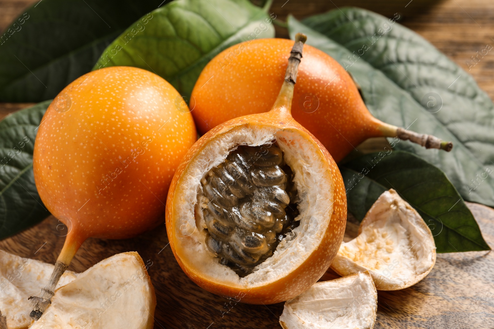 Photo of Delicious ripe granadillas on wooden table, closeup