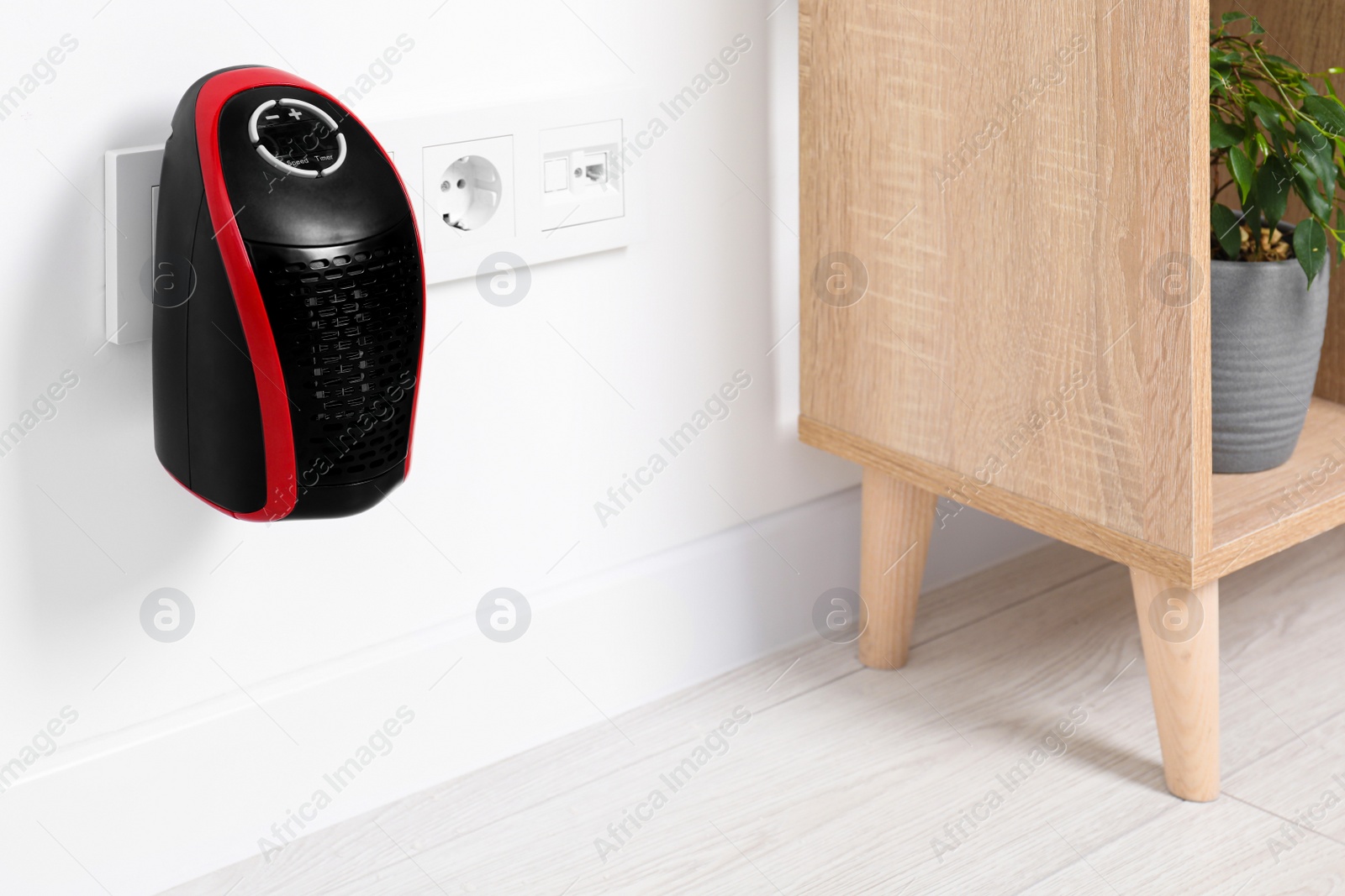 Photo of Portable electric heater on white wall indoors. Space for text