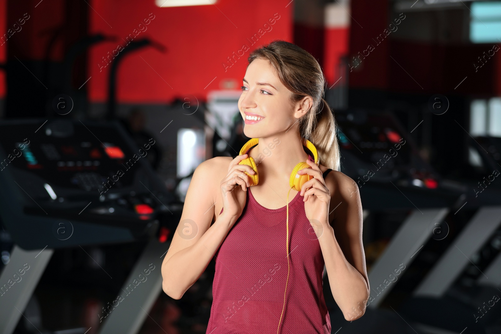 Photo of Beautiful young woman with headphones at gym