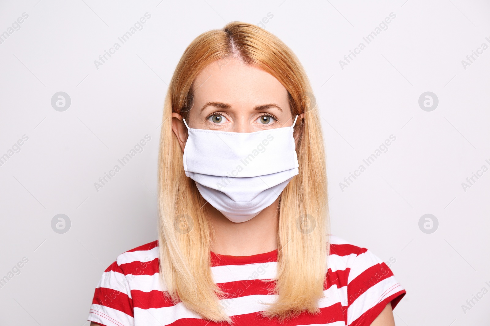 Photo of Woman wearing handmade cloth mask on white background. Personal protective equipment during COVID-19 pandemic