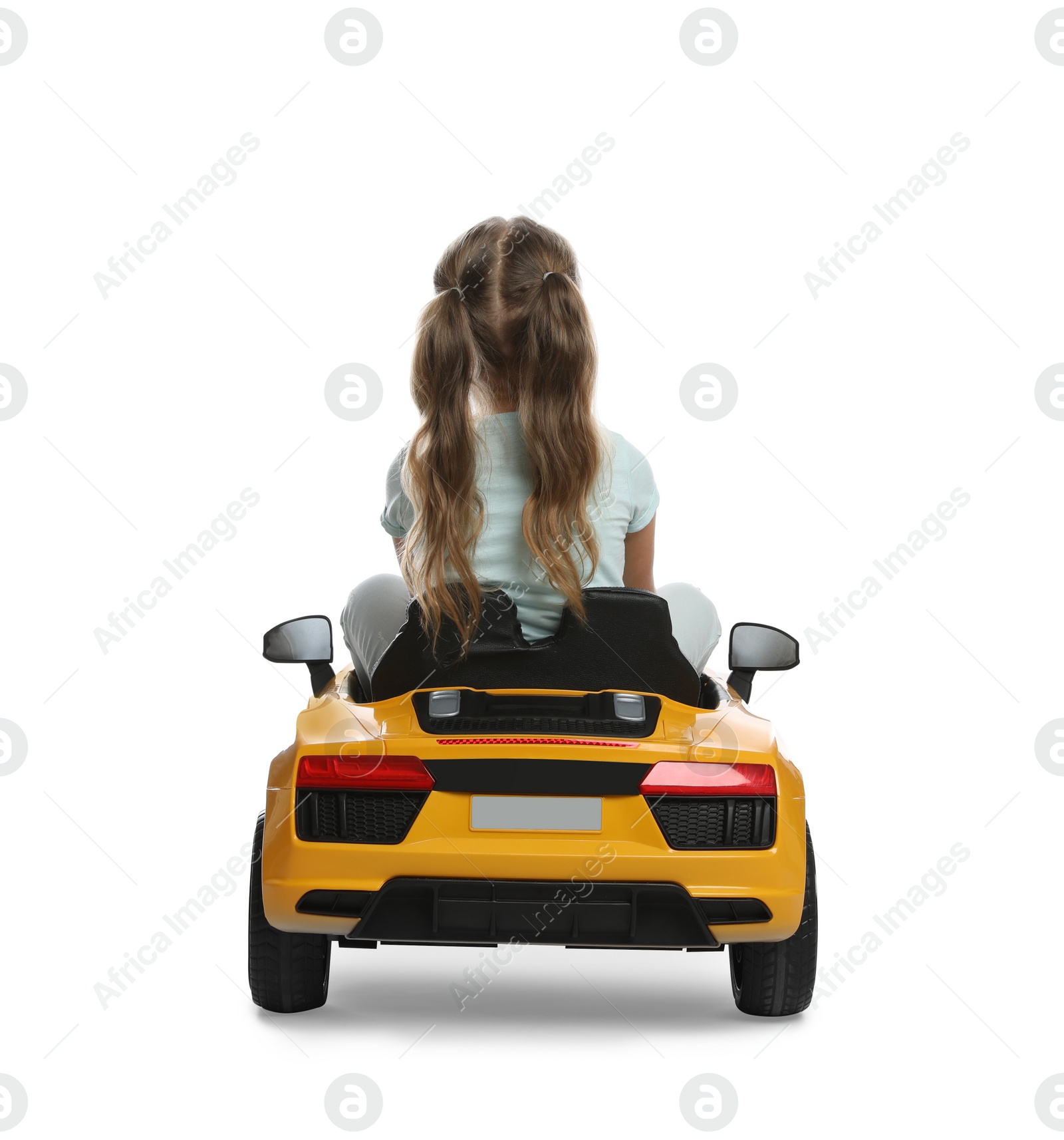 Photo of Cute little girl driving children's electric toy car on white background, back view