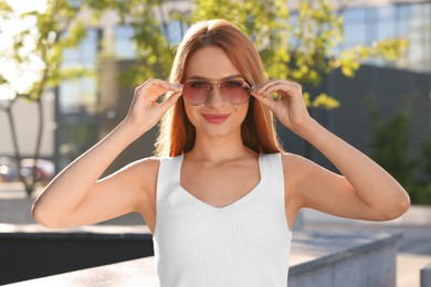 Photo of Beautiful woman in sunglasses on city street