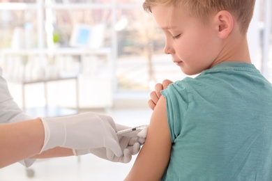 Photo of Doctor vaccinating little boy in hospital