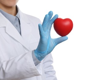Doctor wearing light blue medical glove holding decorative heart on white background, closeup