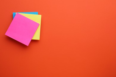 Photo of Paper notes on orange background, top view. Space for text
