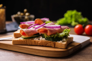 Photo of Delicious sandwiches with ham on wooden table, closeup
