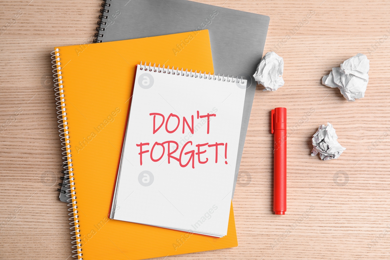 Image of Reminder DON'T FORGET written in notebook on wooden table, flat lay 