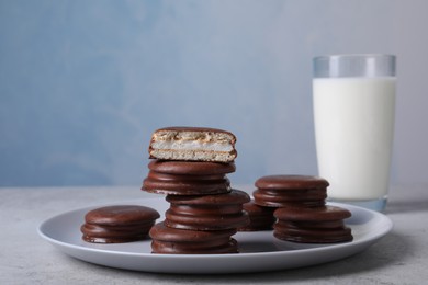 Photo of Tasty choco pies and milk on grey table