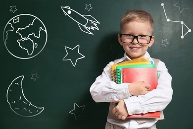 Image of Cute little child wearing glasses near chalkboard with different drawings