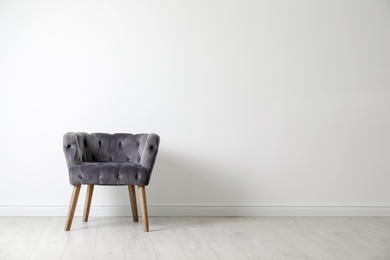 Stylish comfortable armchair near light wall indoors