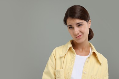 Photo of Portrait of resentful woman on grey background, space for text