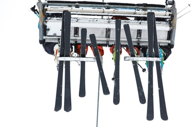 Photo of People using ski lift at mountain resort, bottom view. Winter vacation