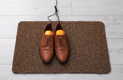 Photo of Shoes with electric dryer on rug indoors, above view