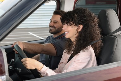 Photo of Driving school. Happy student during lesson with driving instructor in car