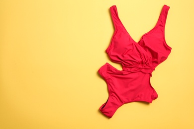 Photo of One-piece swimsuit on color background, top view