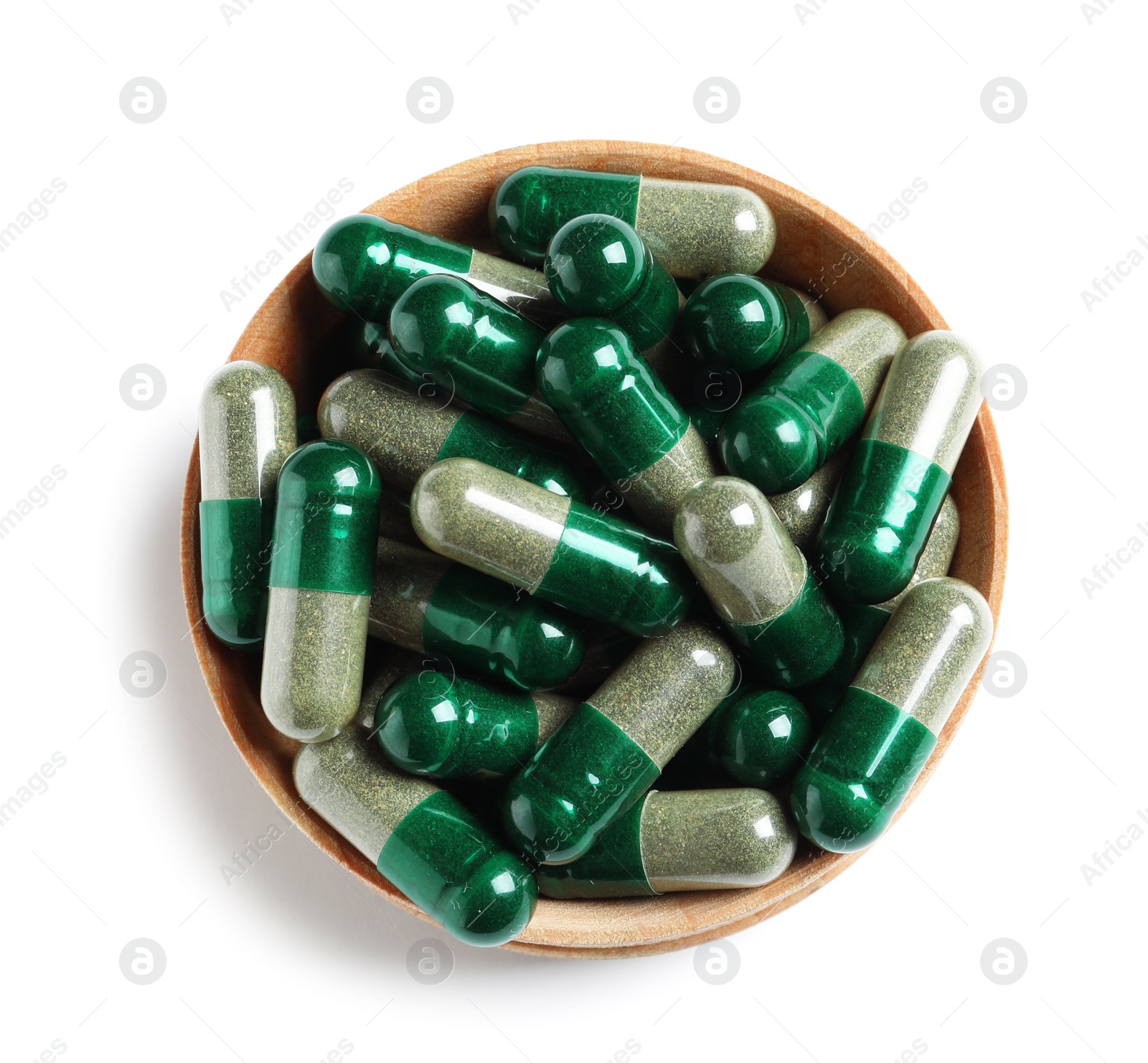 Wooden bowl with green spirulina capsules on white background, top view Photo of Wooden bowl with green spirulina capsules on white background, top view