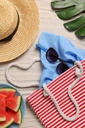 Photo of Flat lay composition with striped beach bag on sand