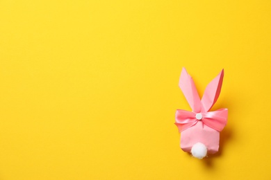 Photo of Creative Easter bunny gift bag on color background, top view with space for text