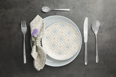 Photo of Stylish setting with cutlery and plates on black table, flat lay