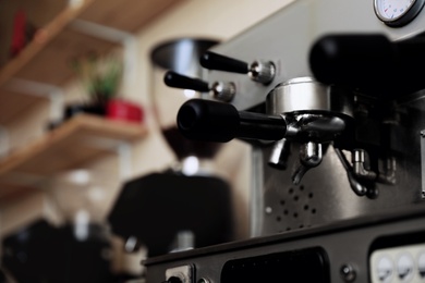 Photo of Modern electric coffee machine with portafilter, closeup