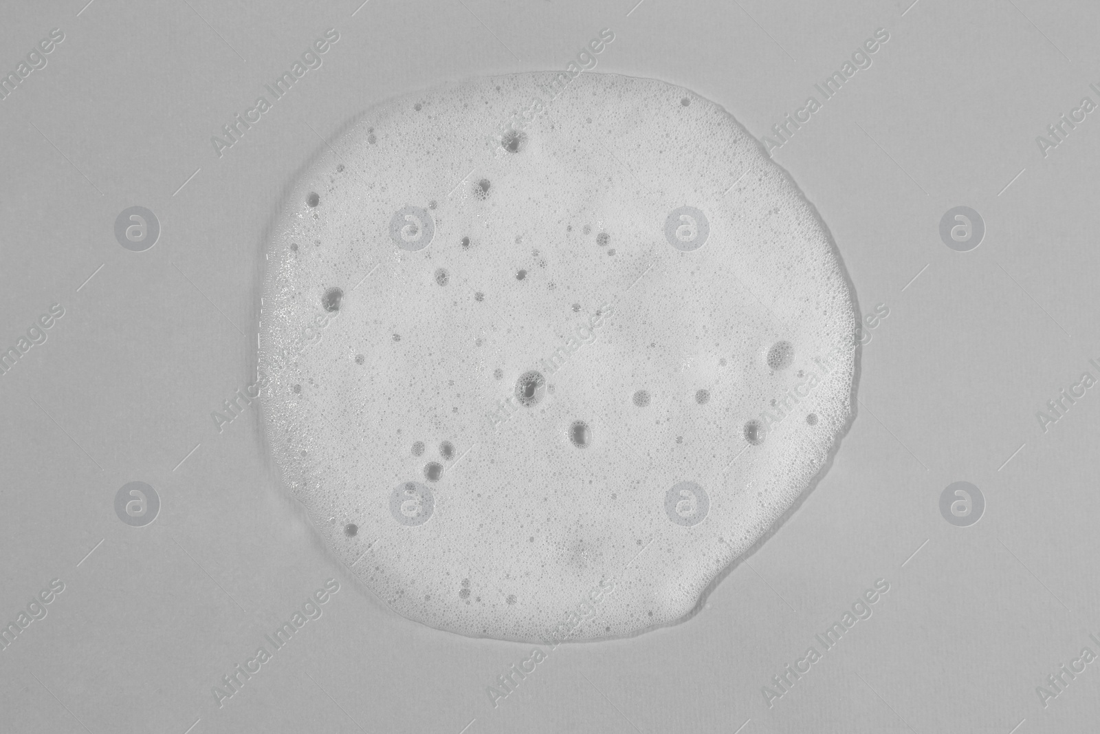 Photo of Sample of cleansing foam on light grey background, top view. Cosmetic product