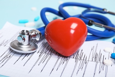 Photo of Stethoscope, cardiogram and heart model on table. Cardiology service