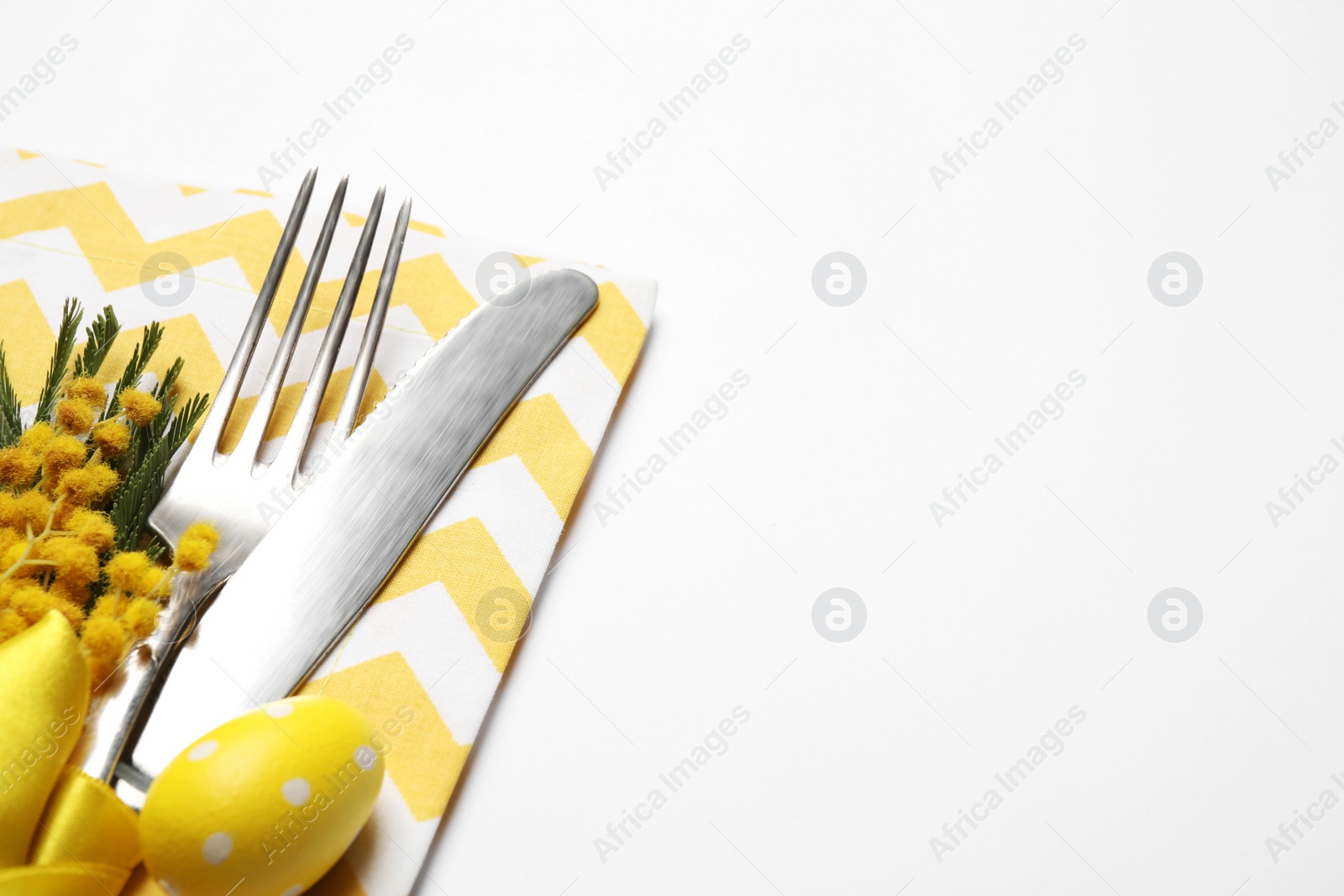 Photo of Cutlery set with floral decor for Easter celebration on white background, closeup