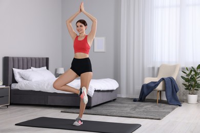 Photo of Happy woman doing morning exercise at home. Space for text