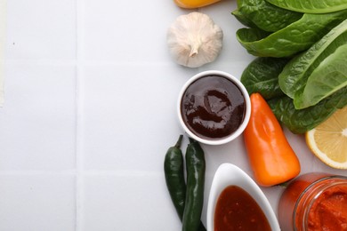 Photo of Different marinades and products on white tiled table, flat lay. Space for text