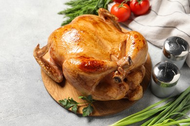Photo of Tasty roasted chicken with different products on light grey table