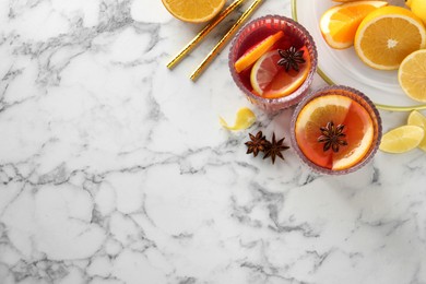 Photo of Aromatic punch drink and ingredients on white marble table, flat lay. Space for text