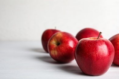 Photo of Ripe red apples on white wooden table. Space for text