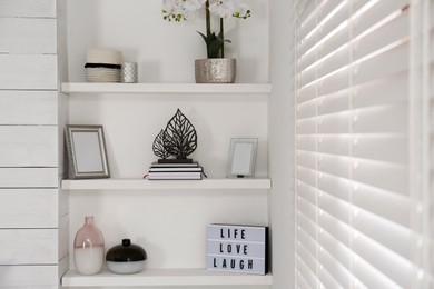 Photo of Wall shelves with beautiful decor elements indoors. Interior design