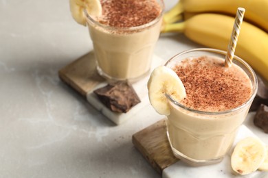 Photo of Tasty banana smoothie, fresh fruits and chocolate on white marble table. Space for text