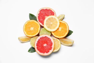 Photo of Different cut citrus fruits and leaves on white table, flat lay