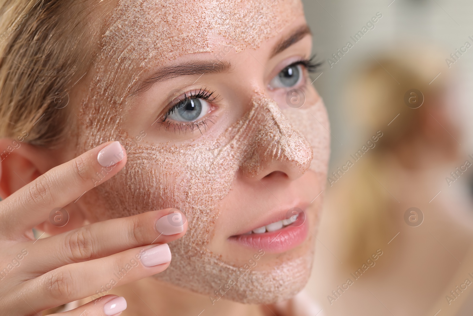 Photo of Woman applying face mask on blurred background, closeup. Spa treatments