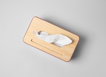 Photo of Holder with paper tissues on light grey background, top view