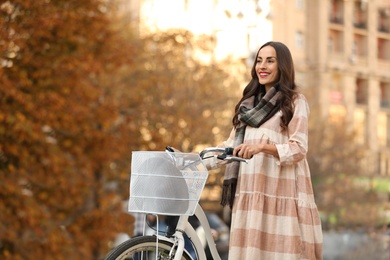 Photo of Beautiful happy woman with bicycle on city street