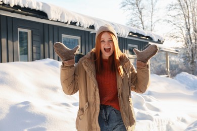 Photo of Portrait of emotional young woman on snowy day outdoors. Winter vacation