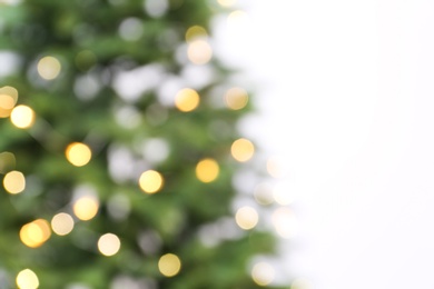 Photo of Blurred view of beautiful Christmas tree with fairy lights on white background