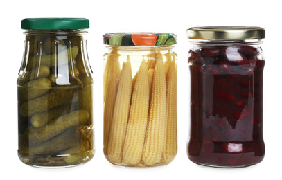 Photo of Glass jars of different pickled vegetables isolated on white