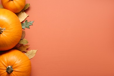 Photo of Thanksgiving day. Flat lay composition with pumpkins and different leaves on orange background, space for text