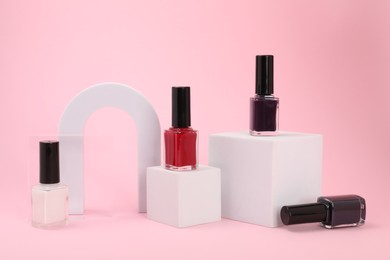 Stylish presentation of nail polishes on pink background
