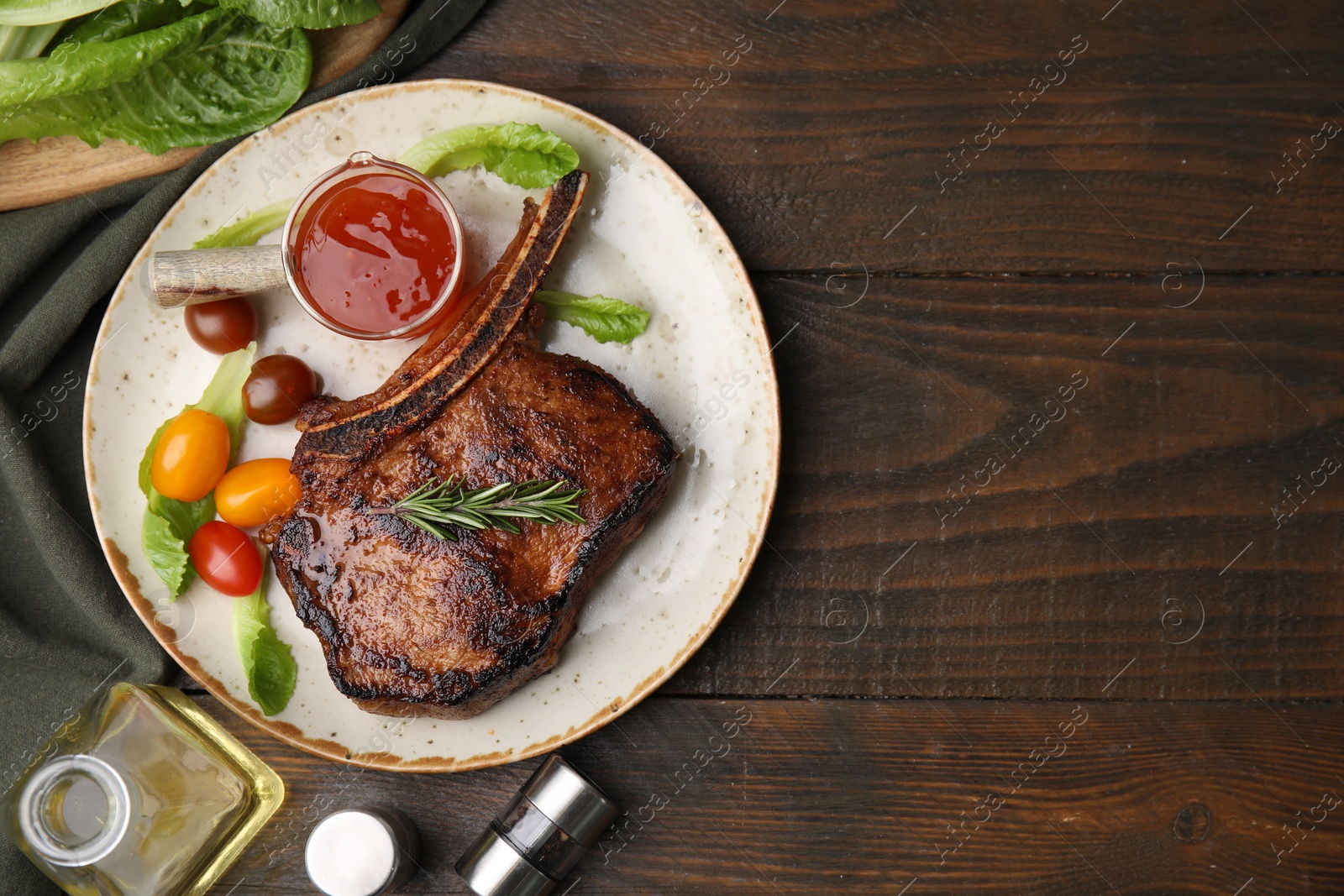 Photo of Tasty grilled meat, rosemary, tomatoes and marinade on wooden table, flat lay. Space for text