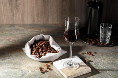 Photo of Coffee liqueur and beans on textured table